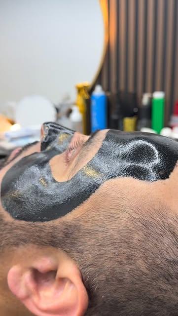 Cliente con mascarilla negra durante la limpieza facial