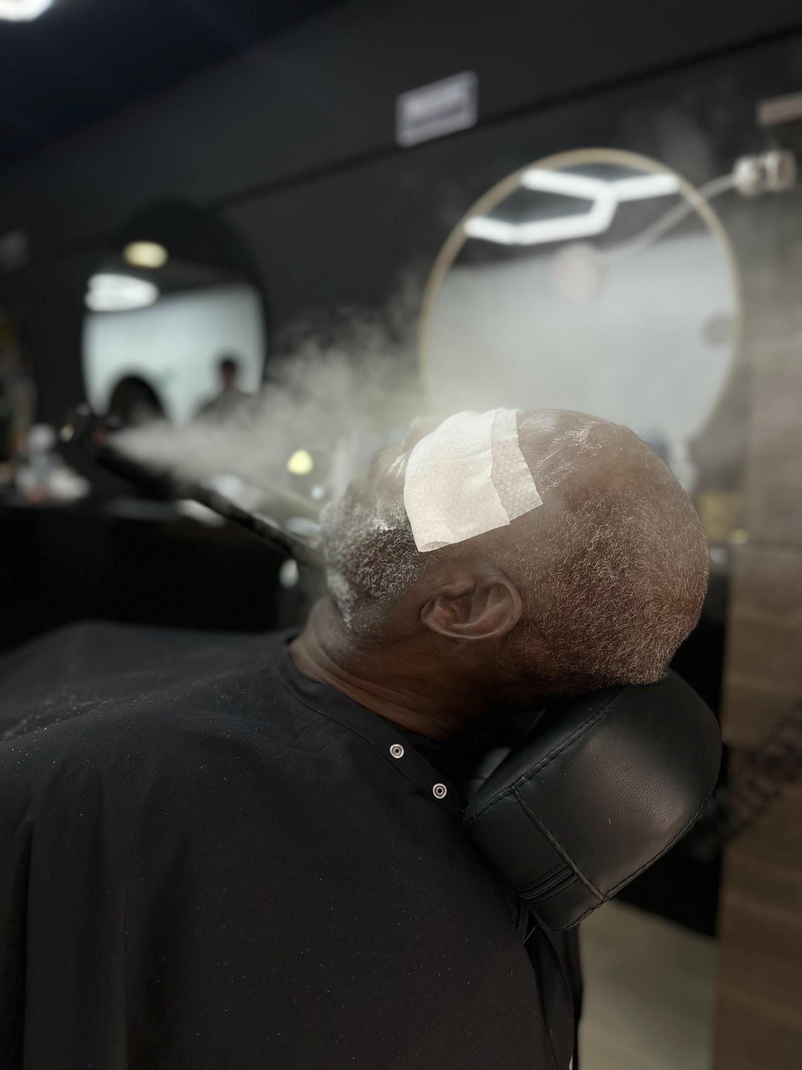 Cliente recostado recibiendo vapor de ozono en la barba